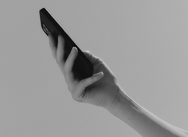 A hand holding a phone to search