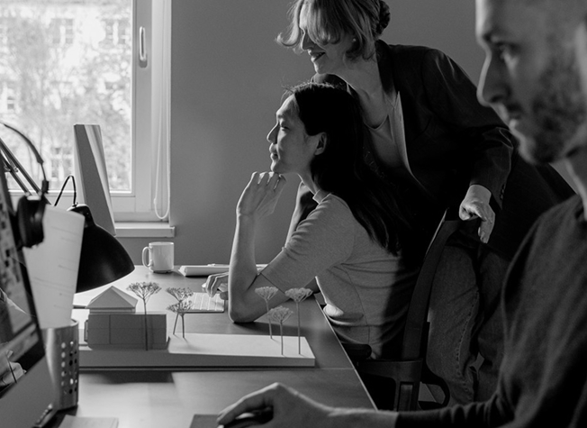 A team reviewing a website design together at a desk